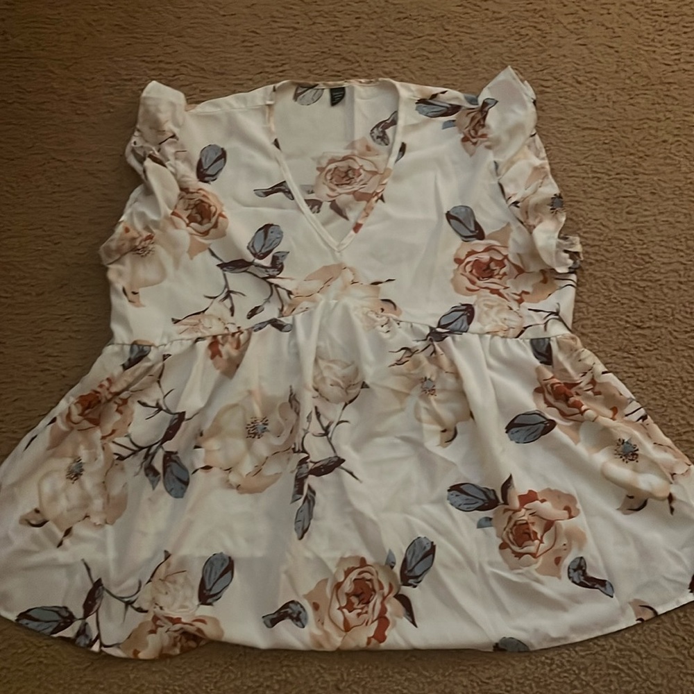 This is a white shirt with floral accents from Shein. V neck with ruffle sleeves